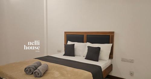 a bedroom with a bed with two pillows on it at nelli house in Galle