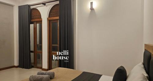 a bedroom with a bed and a door with a window at nelli house in Galle
