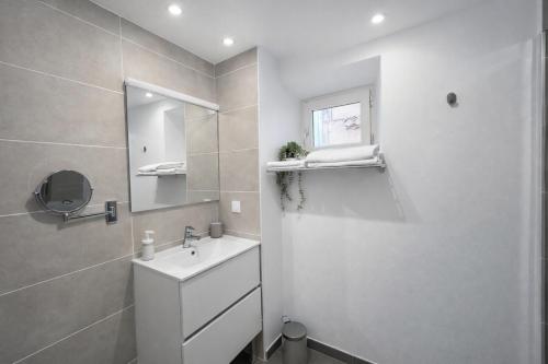 a white bathroom with a sink and a mirror at SOUS LES PLATANES in Velaux