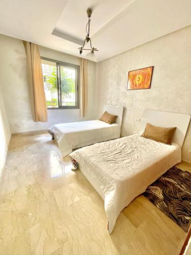 a bedroom with two beds and a window at Airport Luxury Residence Taj collection 1 in Casablanca