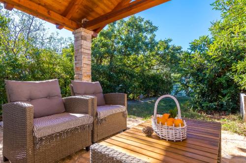 a patio with two chairs and a basket of oranges at House Dobrila in Igrane