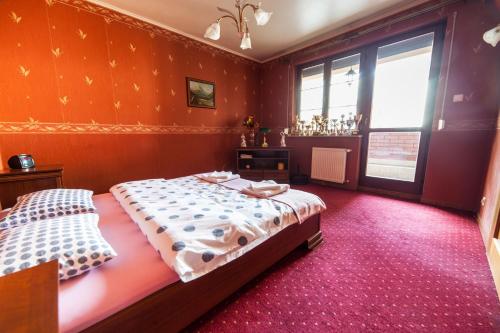Apartament Eva في فروتسواف: غرفة نوم بسريرين في غرفة بجدران حمراء