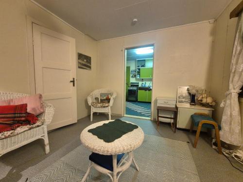 a living room with a table and a chair at Sjarmerende 50-tallshus med utsikt og ro in Olderdalen