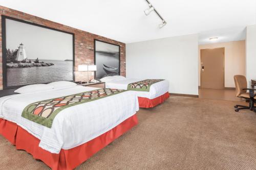 a hotel room with two beds and a large window at Super 8 by Wyndham Sudbury ON in Sudbury