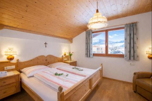 a bedroom with a large bed and a window at Binterhof ROSALPINA APP in Castelrotto
