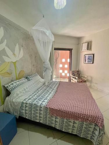 a bedroom with a bed with a mosquito net at Cozy Suite Olinda in Olinda
