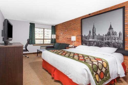 a hotel room with a large bed and a tv at Super 8 by Wyndham Sudbury ON in Sudbury