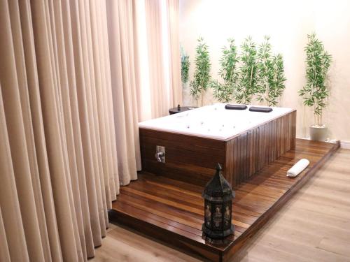 a bath tub sitting in a room with curtains at Minas Platinum Hotel & Convention in Conselheiro Lafaiete