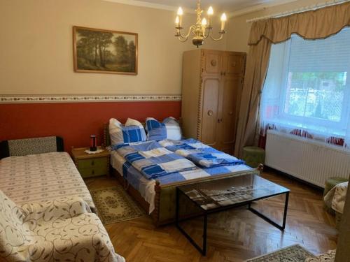 a bedroom with a bed and a table and a window at Beni Apartman in Balatonlelle