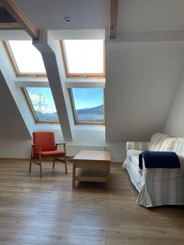 a room with two windows and a couch and a table at Reitterhof in Laufnitzdorf in Frohnleiten