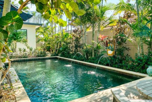 a swimming pool in the middle of a garden at Art Deco Apt w Pool One Mile to Beach Pets Welcome in Lake Worth