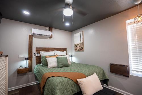 a bedroom with a bed with a green comforter at BOHO-MOD STUDIO APARTMENTs in Ferris