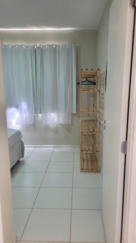 a room with a white tiled floor and a window at Apartamento no Cond Vinhedos in Petrolina