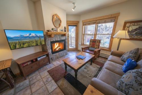 a living room with a fireplace and a tv at Tenderfoot Lodge 2620 by SummitCove Lodging in Keystone