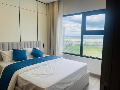 a bedroom with a bed with a large window at Đô thị Vinhomes Grand Park in Gò Công