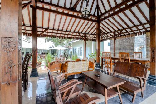 a wooden pavilion with a table and chairs at HOME 88 Feels Like Home in Sleman