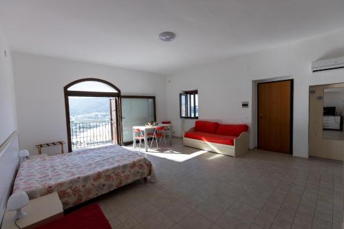 a bedroom with a bed and a red couch at Appartamenti Castello in Peschici