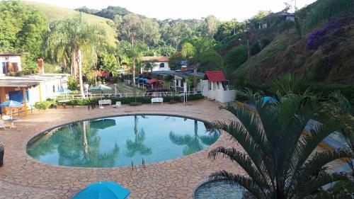 a large swimming pool in the middle of a resort at Recanto dos Carvalhos - Pousada Camping in São Lourenço
