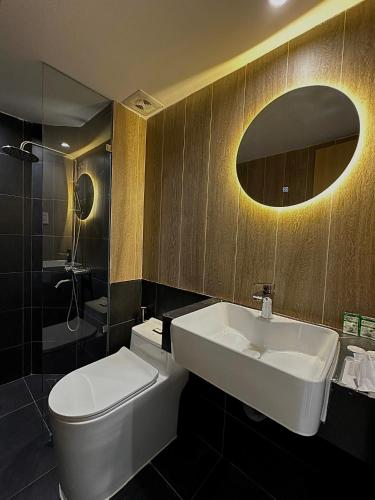 a bathroom with a sink and a toilet and a mirror at Arista - Thanh My Loi in Ho Chi Minh City