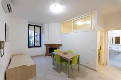 a dining room with a table and green chairs at Appartamenti Castello in Peschici