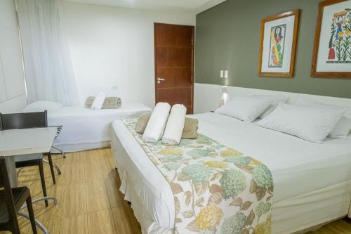 a hotel room with two beds and a table at Porto da Serra Hotel in Gravatá