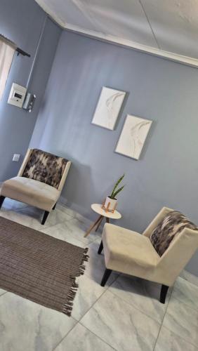 a living room with two chairs and a table at KeAnna STAYS Apartment in Tsumeb