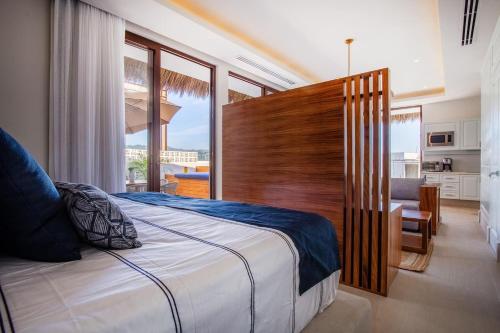 a bedroom with a large bed and a large window at Elegance - Jungle meet with private pool heated in Bucerías