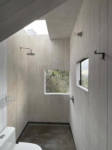 a bathroom with a toilet and a window at Refugio costero Molle in Boca Pupuya
