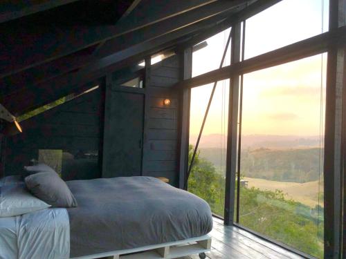 a bedroom with a bed and a large window at Refugio costero Molle in Boca Pupuya