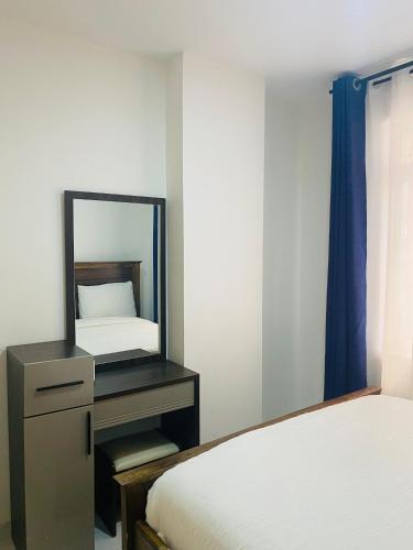 a bedroom with a mirror next to a bed at Residence Next Door Gz in Kiambu