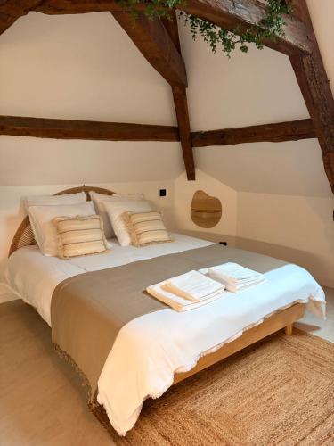 a bedroom with a large bed with wooden beams at Suite Spa Cinta in Trie-Château