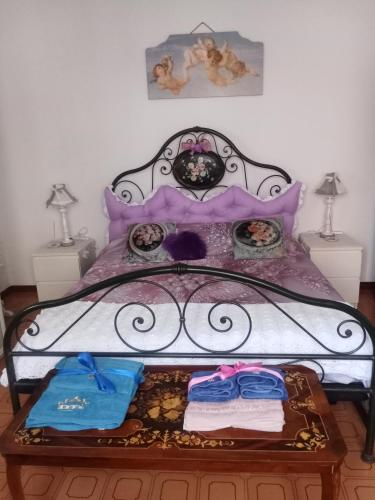 a bed with a metal frame with clothes on it at Villa Rosa in Acqualagna