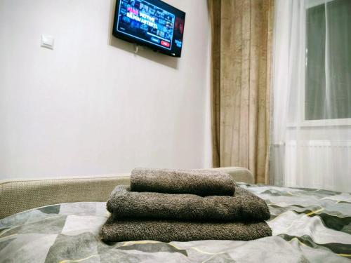 a pile of towels sitting on a bed with a television at Modern Studio AFI Arad Self Check-in in Arad