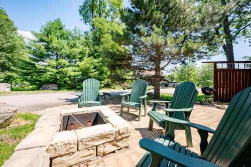 three green chairs and a dog in a fire pit at Dream On by Railey Vacations in Oakland