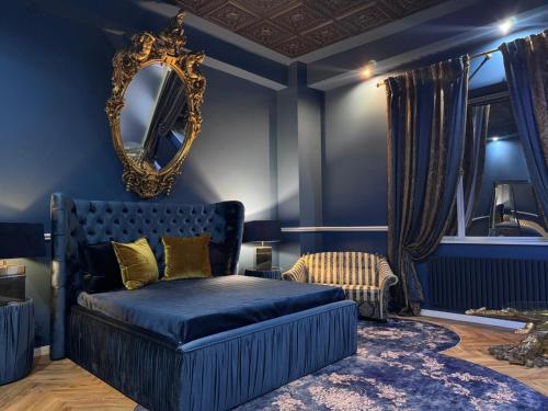a blue bedroom with a bed and a mirror at Secret Labelle Époque Hideaway in Berlin