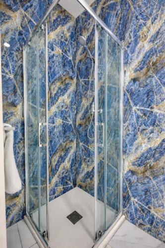 a shower with a blue and gold marble wall at Kalimera Studios in Hamrun