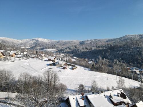 a town covered in snow with mountains in the background at Agroturystyka u Matysa Wisła apartamenty i pokoje Widoki na góry Basen grill balia szlaki turystyczne spacery Zwierzęta duży plac zabaw in Wisła