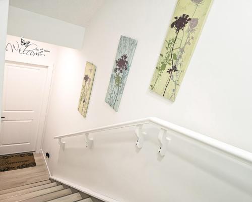 ein weißes Zimmer mit Blumen an der Wand in der Unterkunft Ebenz Apartment in Calgary