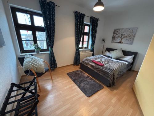 a living room with a bed and a couch and windows at Macabu Apartment Porto in Plauen