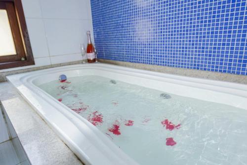a bath tub filled with water in a bathroom at Porto da Serra Hotel in Gravatá