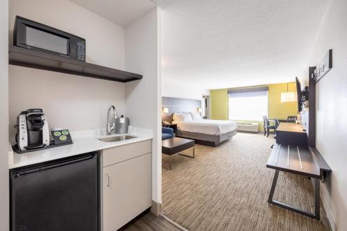 a hotel room with a kitchen and a bedroom at Holiday Inn Express Winona by IHG in Winona
