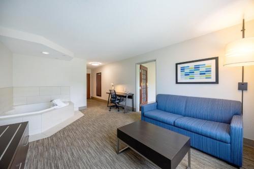 a living room with a blue couch and a tub at Holiday Inn Express Winona by IHG in Winona