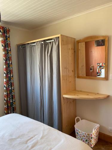 a bedroom with a bed and a wooden cabinet at Tall Ar Groas in Plogoff