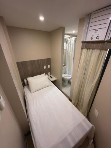 a small room with a bed and a bathroom at Pajuçara Praia Hotel in Maceió