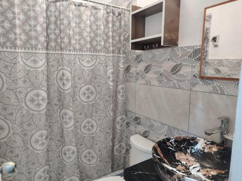 a bathroom with a toilet and a shower curtain at Ocean Glips II in Punta Negra