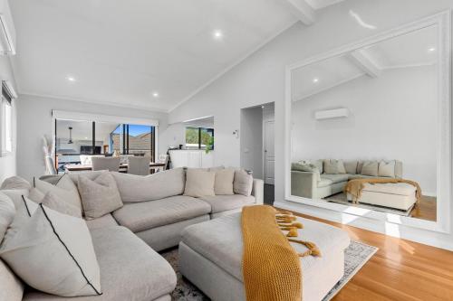 a living room with a couch and a large mirror at Central Geelong Escape Spa, Fire Pit, Sleeps 10 in Geelong