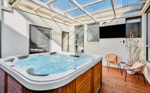 a hot tub in a room with a ceiling at Central Geelong Escape Spa, Fire Pit, Sleeps 10 in Geelong