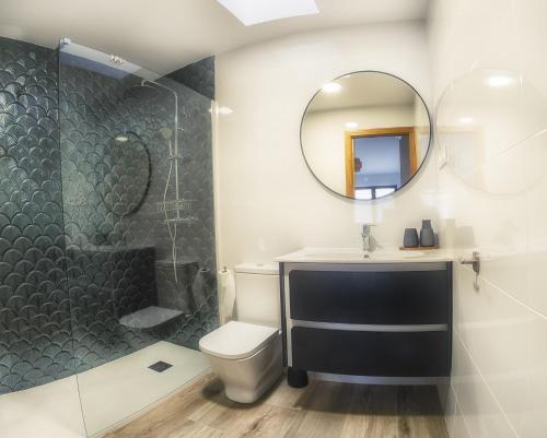 a bathroom with a shower and a toilet and a sink at La Casina Casa rural con piscina privada y patio cerca de Gredos in Navalcán