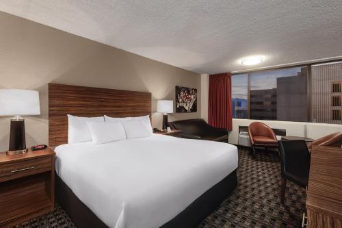 a hotel room with a large bed and a desk at The D Las Vegas in Las Vegas