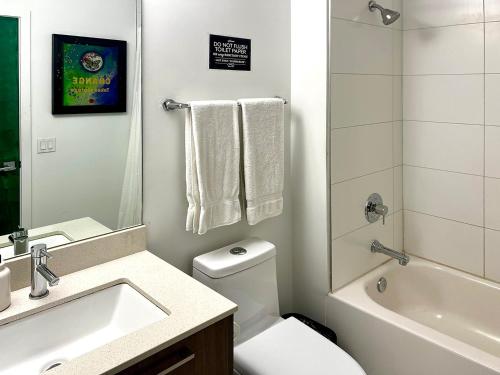 a bathroom with a sink and a toilet and a bath tub at The Art House Little Havana in Miami